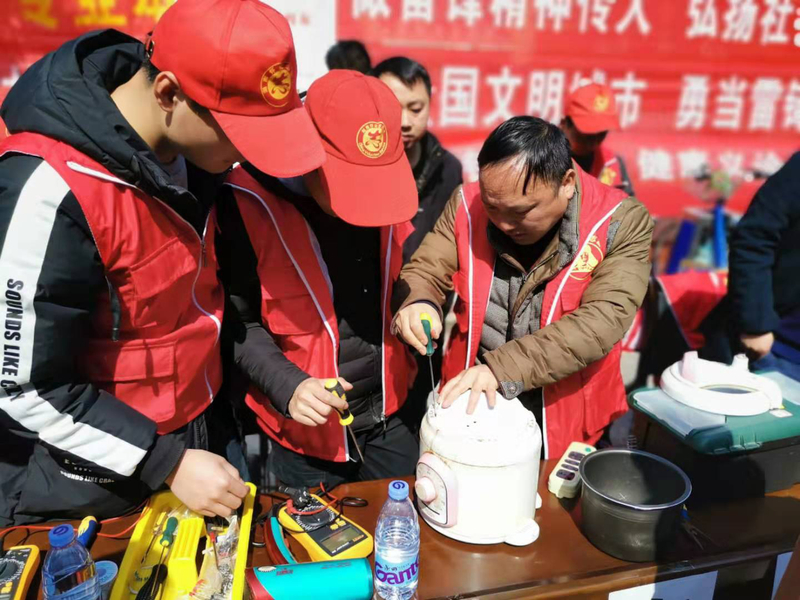 1551833913210055262.jpg 2 志愿者在江老师指导下修理电饭煲.jpg